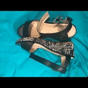 Black sandals with black and white leaves on heel